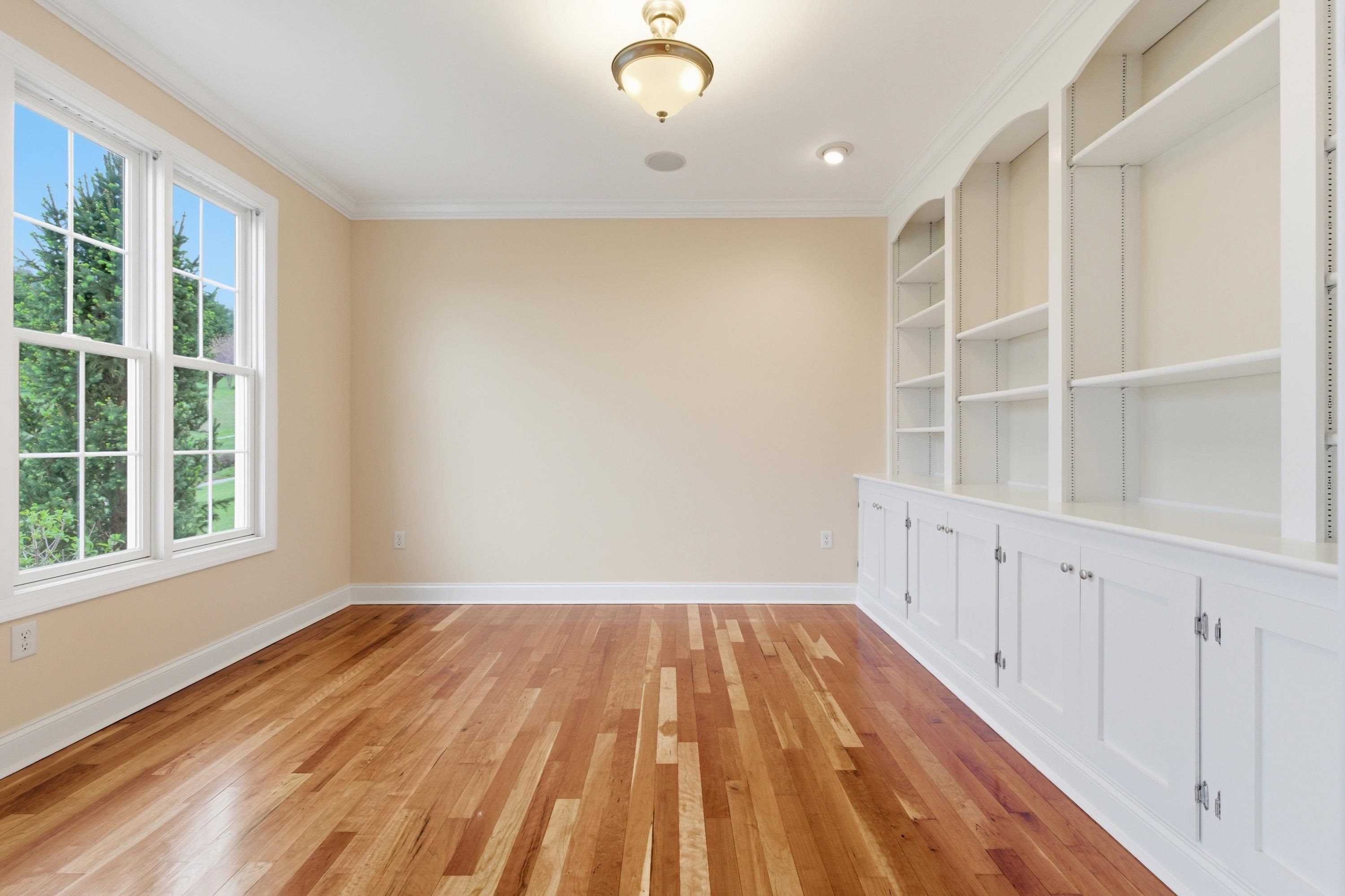 2625 Rising Rock Court Harrisonburg, VA 22802 - Photo 21 of 73 Off the foyer space is a beautiful room featuring a lot of built-in shelving. This room offers hardwood flooring throughout, large windows, and would be perfect for use as a home office or additional family room.