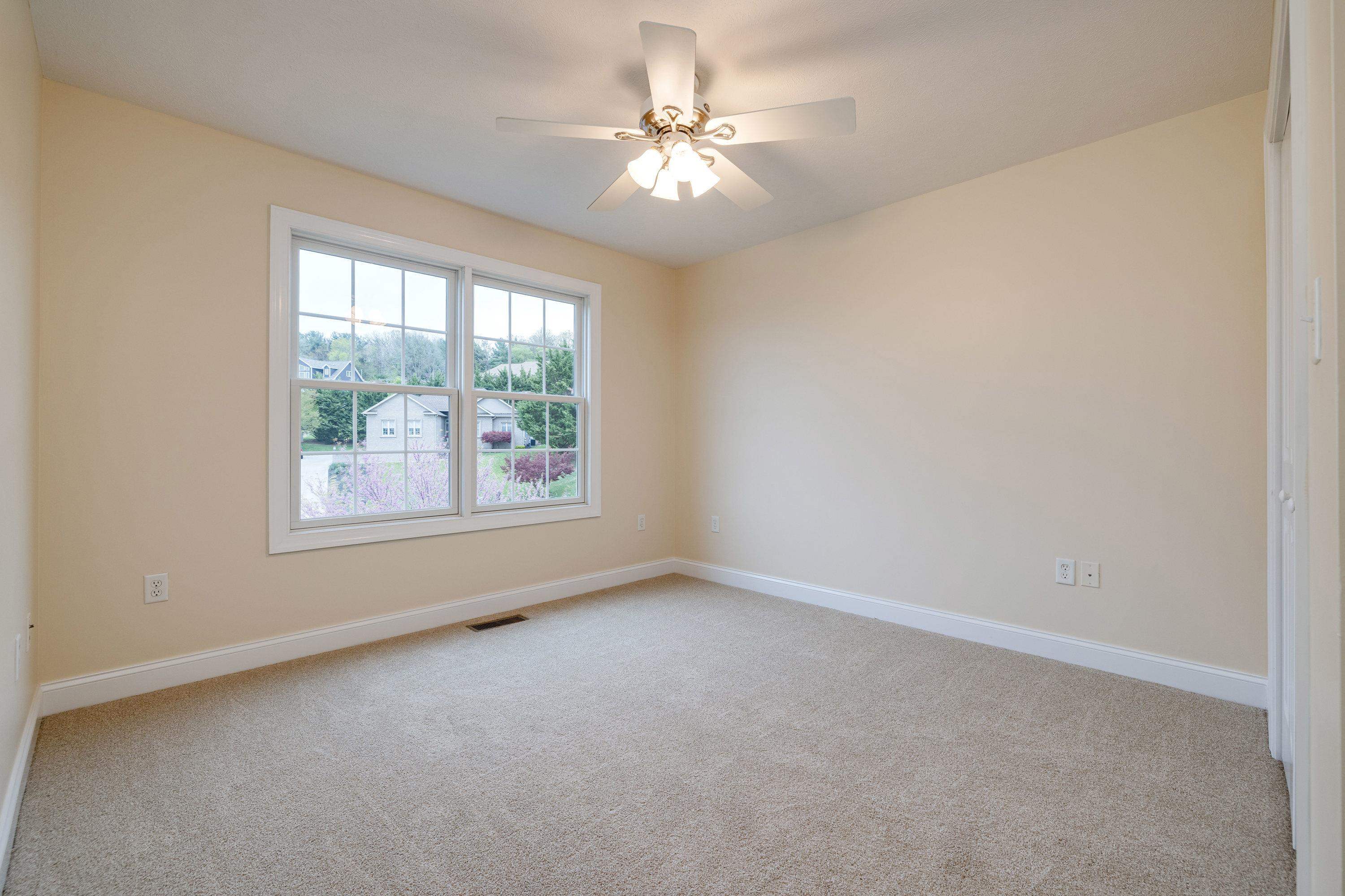 2625 Rising Rock Court Harrisonburg, VA 22802 - Photo 33 of 73 An upper level bedroom features a ceiling fan, comfortable flooring, large closet space, and lots of natural light.