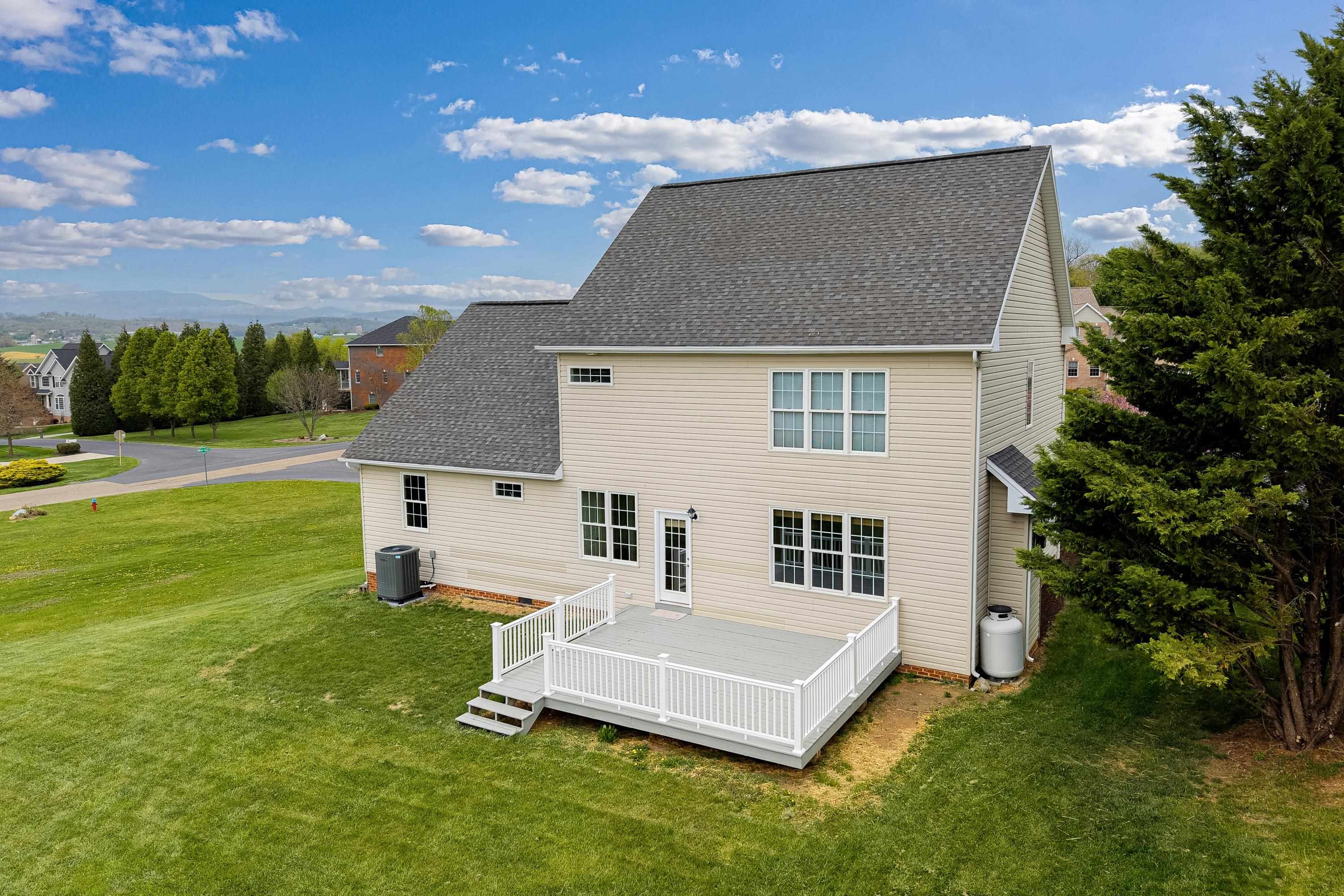 2625 Rising Rock Court Harrisonburg, VA 22802 - Photo 59 of 73 The rear view of the home highlights the mature yard, large deck with vinyl railings, mostly-level lot, and storage building.