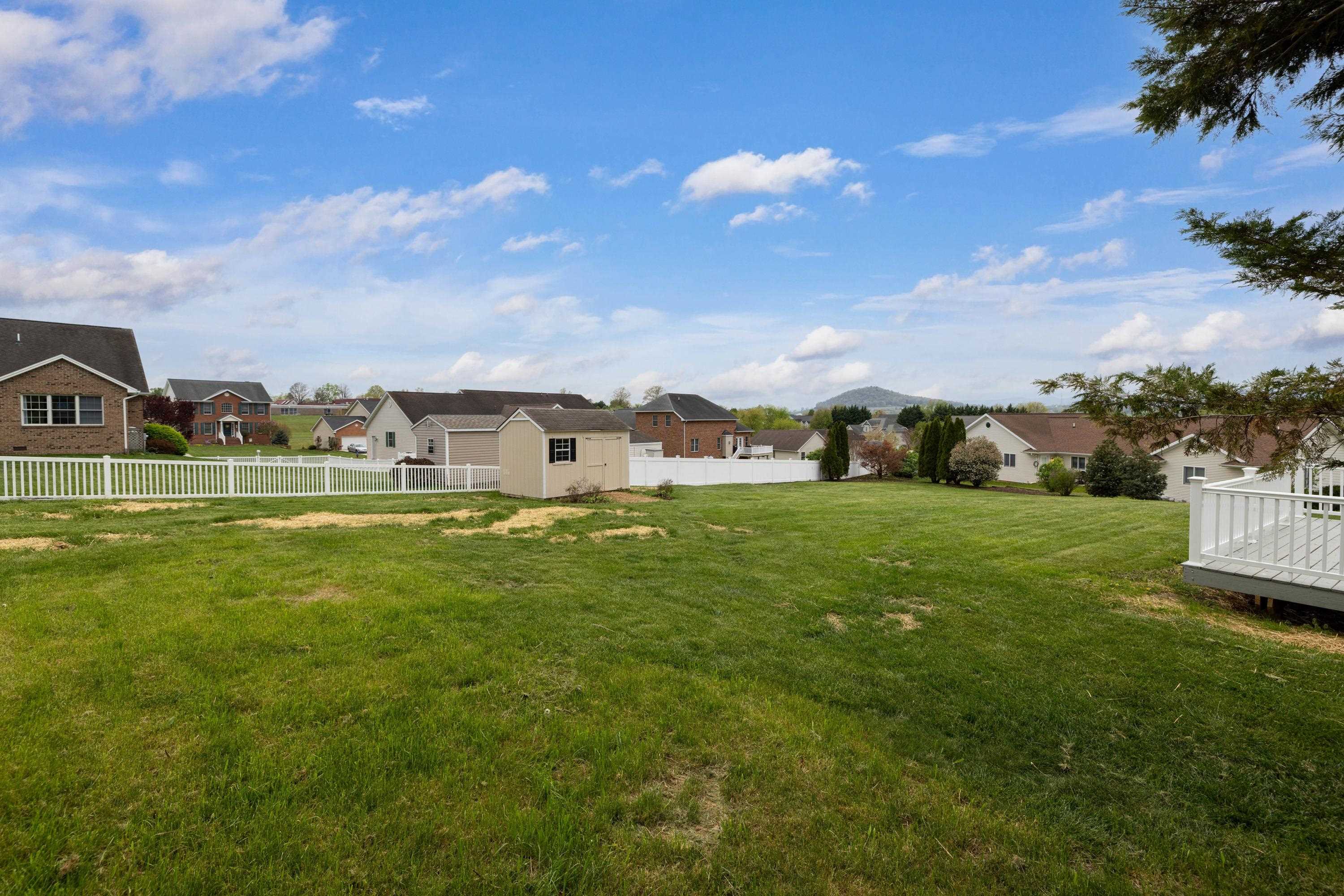 2625 Rising Rock Court Harrisonburg, VA 22802 - Photo 63 of 73 The rear view of the home highlights the mature yard, large deck with vinyl railings, mostly-level lot, and storage building.