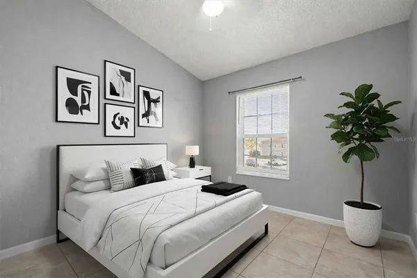 a bedroom with a bed and a potted plant