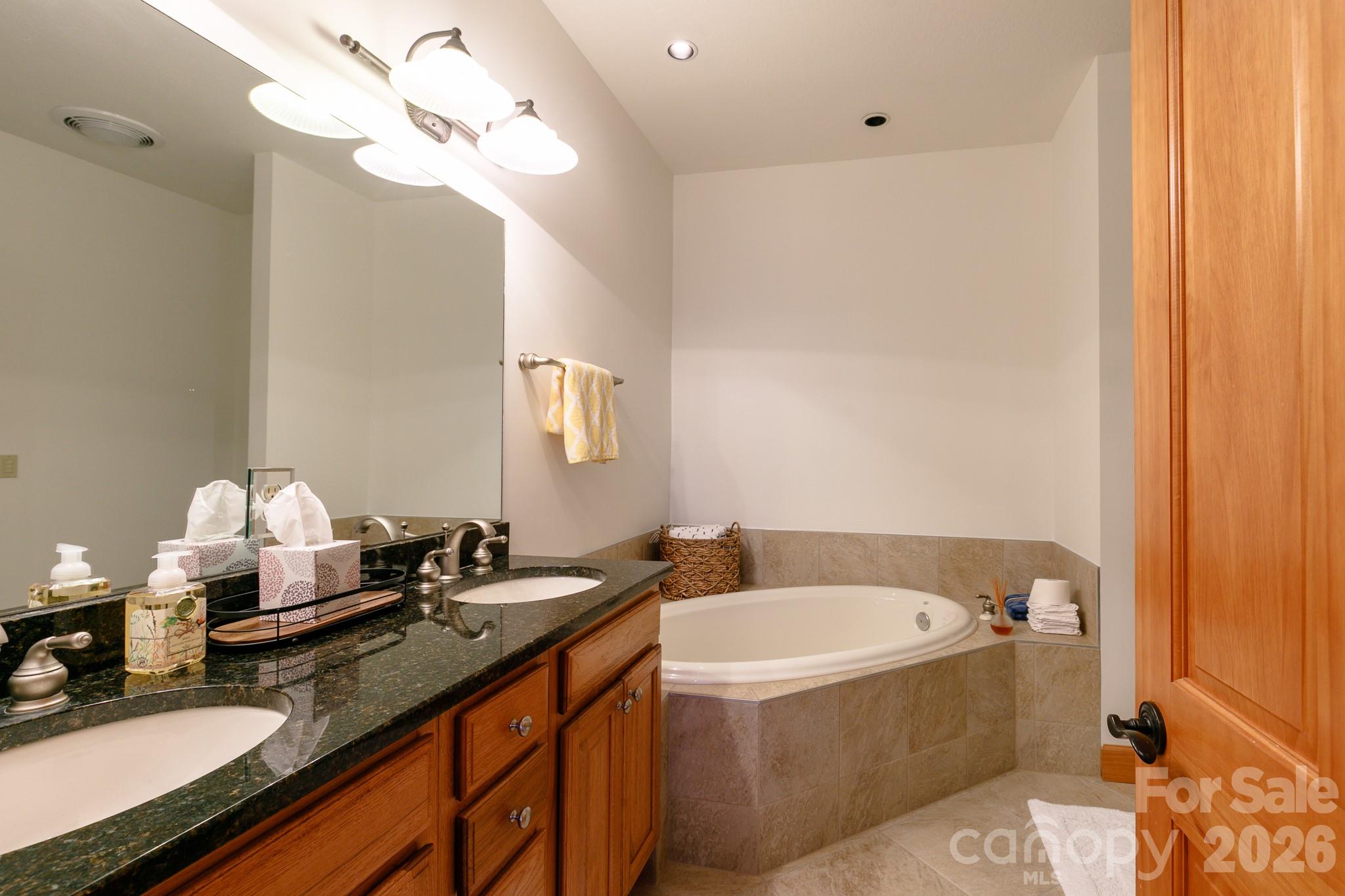 528 Andrew Banks Road, Unit A/3 Burnsville, NC 28714 - Photo 25 of 30 a bathroom with a granite countertop sink and a mirror