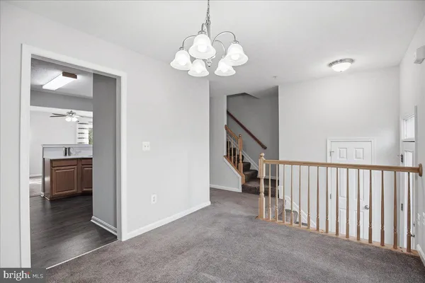 a view of a hallway with dining area and chandelier