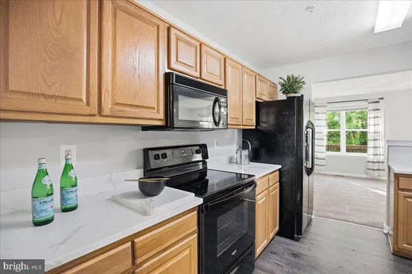 a kitchen with stainless steel appliances granite countertop a refrigerator a stove a sink dishwasher and microwave oven with cabinets