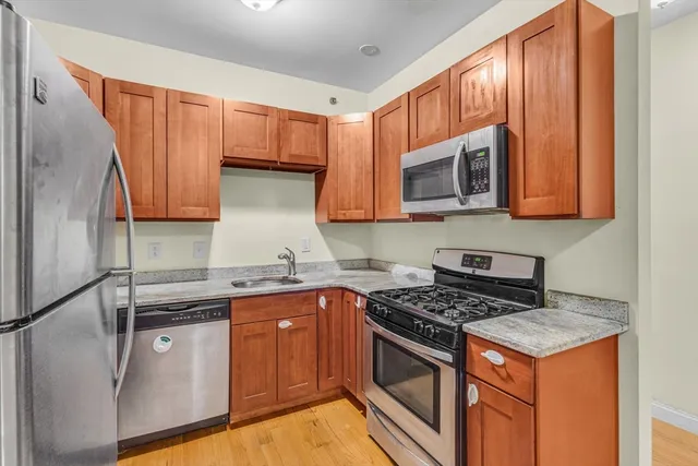 a kitchen with stainless steel appliances granite countertop a stove a sink and a microwave