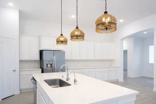 a kitchen with kitchen island stainless steel appliances a table and sink