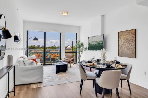 a dining room with furniture window and wooden floor