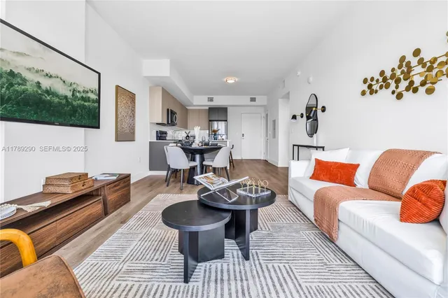 a living room with furniture a rug and a table