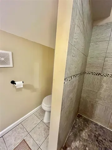 a bathroom with a toilet and a shower