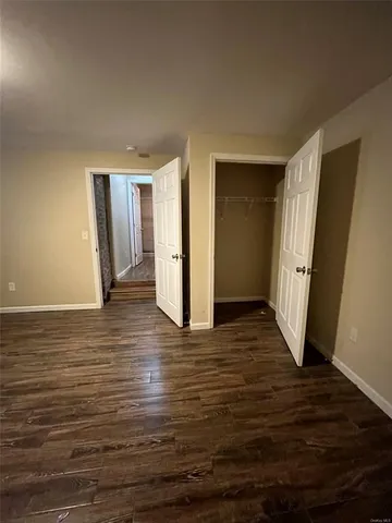 an empty room with wooden floor and entrance