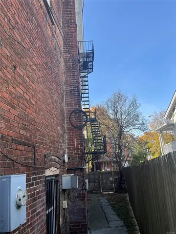 a view of a pathway of a building with wooden fence