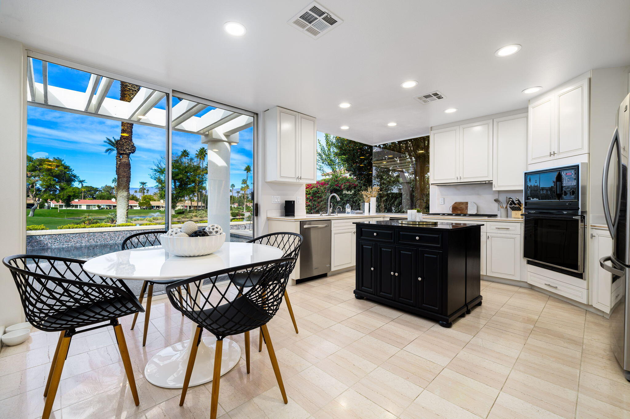 75720 Vista Del Rey Indian Wells, CA 92210 - Photo 11 of 31 a kitchen with a table chairs refrigerator and cabinets
