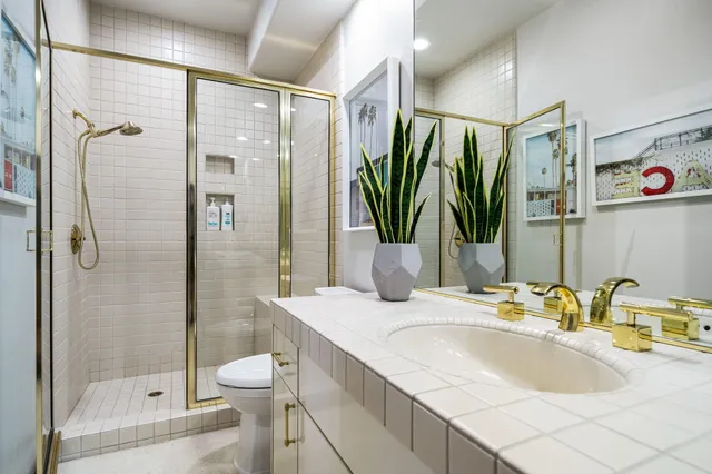 a bathroom with a granite countertop sink a toilet and shower