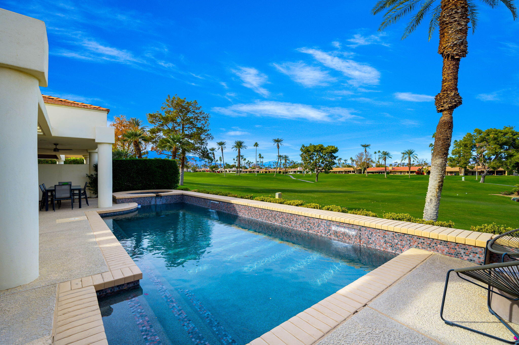 75720 Vista Del Rey Indian Wells, CA 92210 - Photo 26 of 31 a view of a swimming pool and lounge chairs in back yard of the house