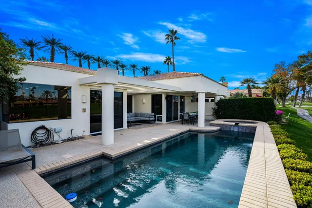 a view of a house with swimming pool and sitting area