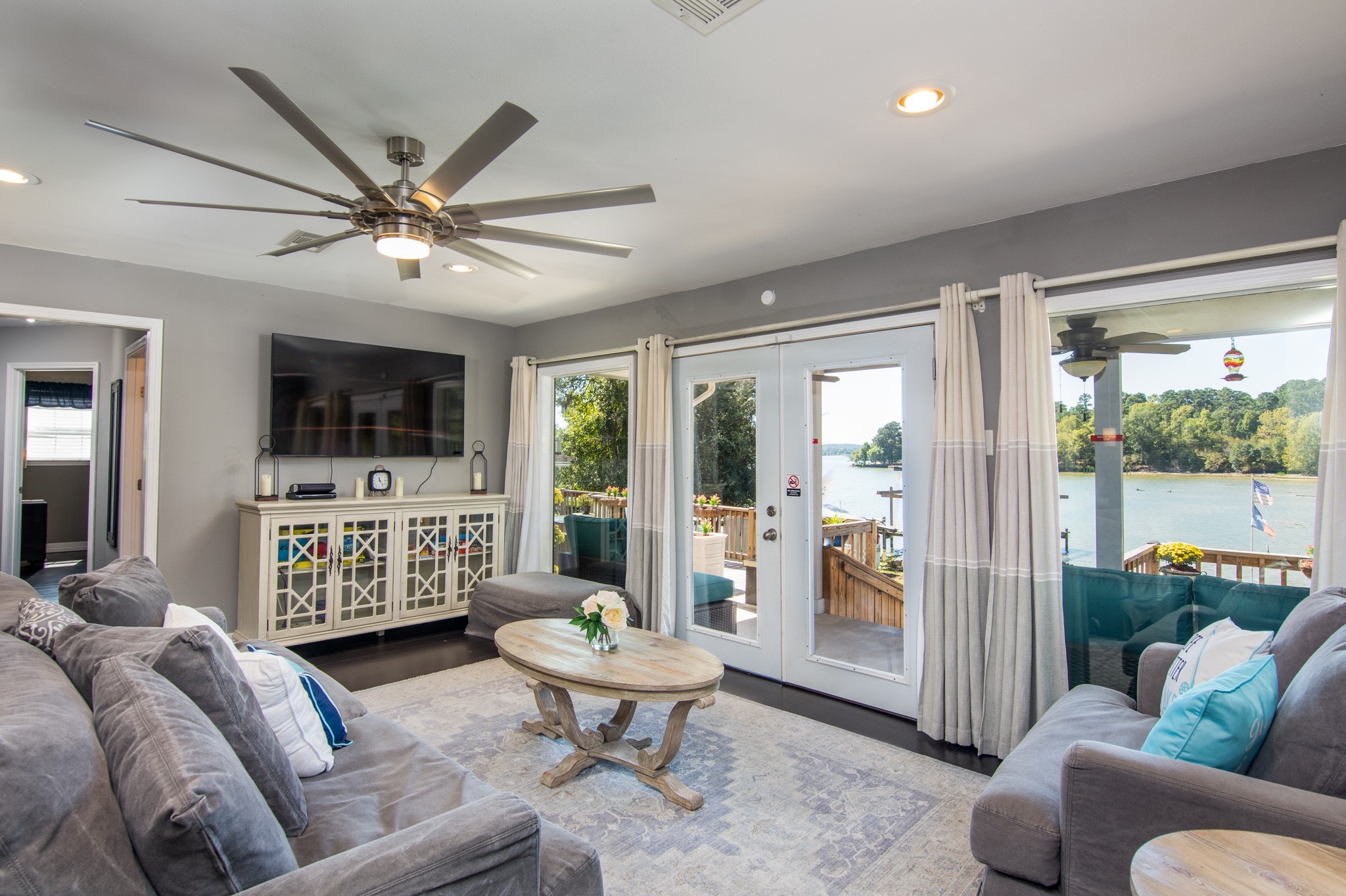 a living room with furniture a flat screen tv and a floor to ceiling window
