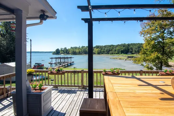 a view of a patio with table and chairs with wooden floor and fence