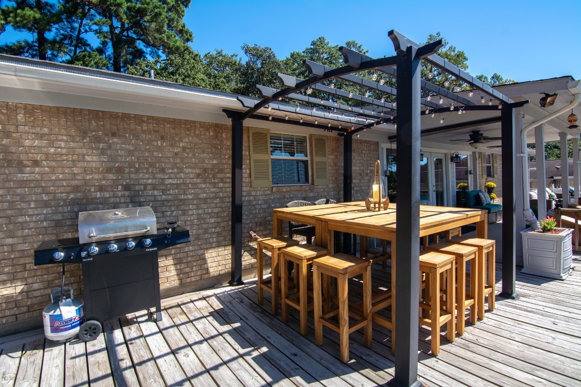 150 Edgewater Way Point Blank, TX 77364 - Photo 19 of 48 a view of a patio with table and chairs with wooden floor and fence