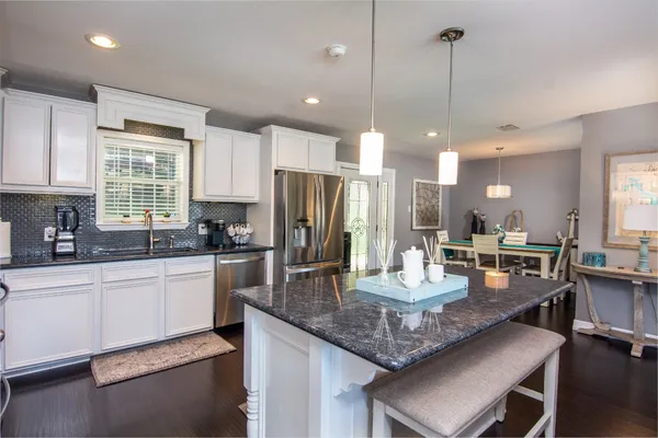 a kitchen with granite countertop kitchen island stainless steel appliances a stove center island a sink cabinets and a counter top space