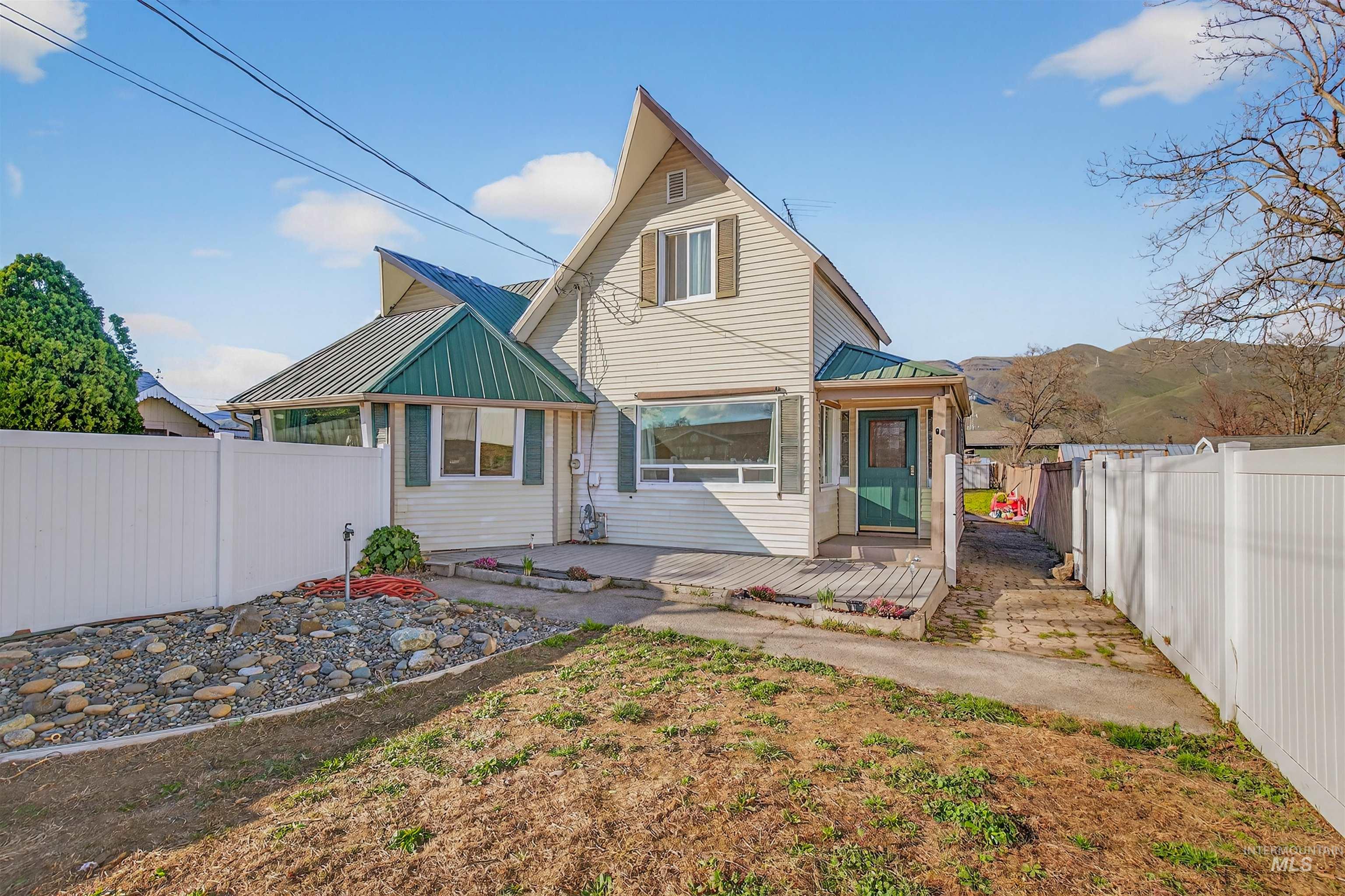1266 Poplar Street Clarkston, WA 99403 - Photo 1 of 31 Back of house with a metal roof, a wooden deck, and a fenced backyard