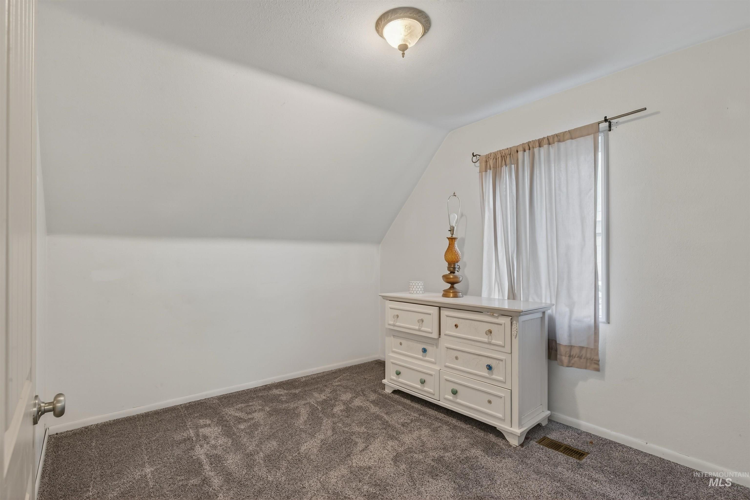 1266 Poplar Street Clarkston, WA 99403 - Photo 24 of 31 Bedroom with vaulted ceiling and dark carpet
