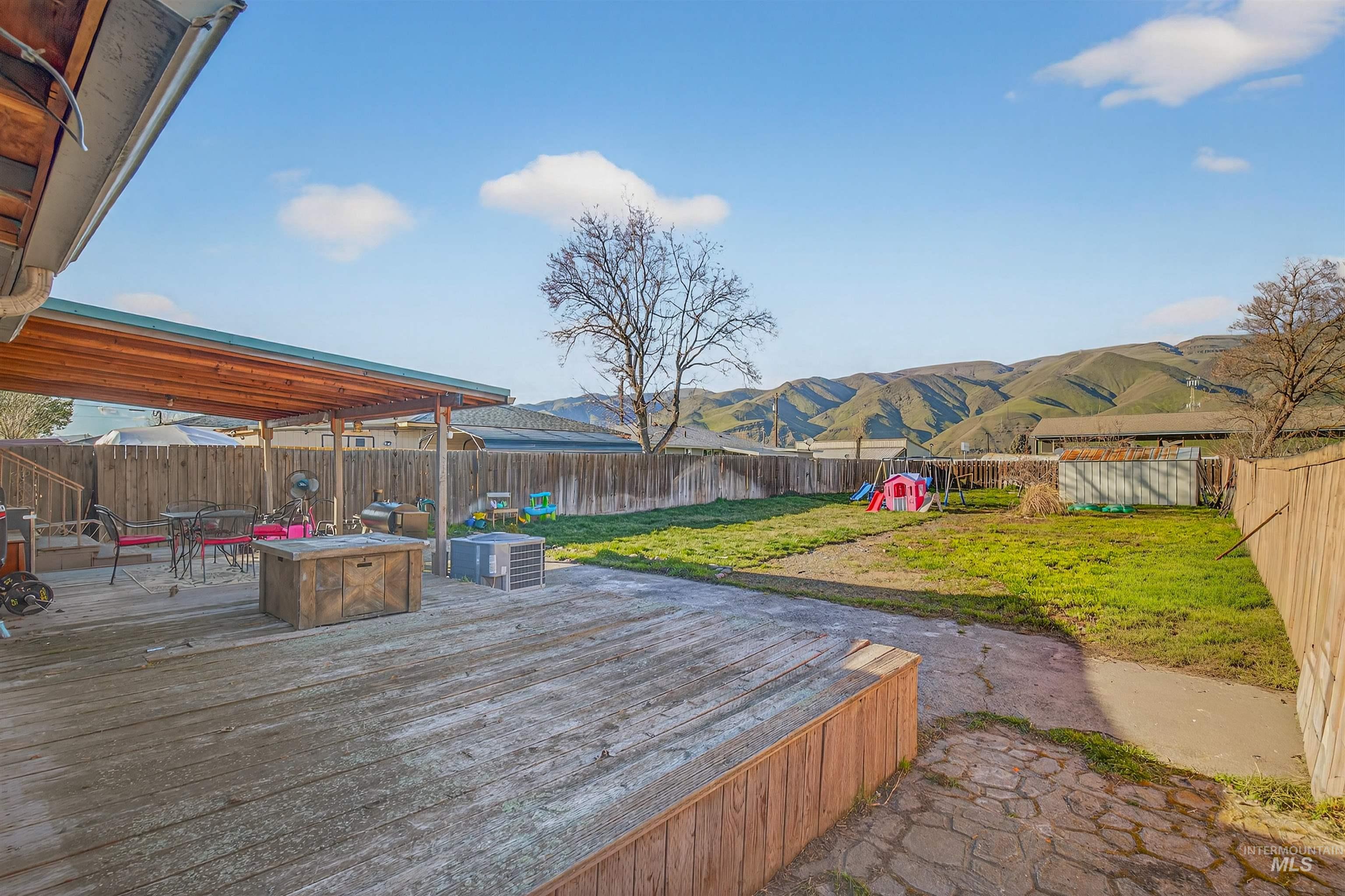 1266 Poplar Street Clarkston, WA 99403 - Photo 27 of 31 Wooden deck featuring a fire pit, a fenced backyard, a mountain view, and outdoor dining space