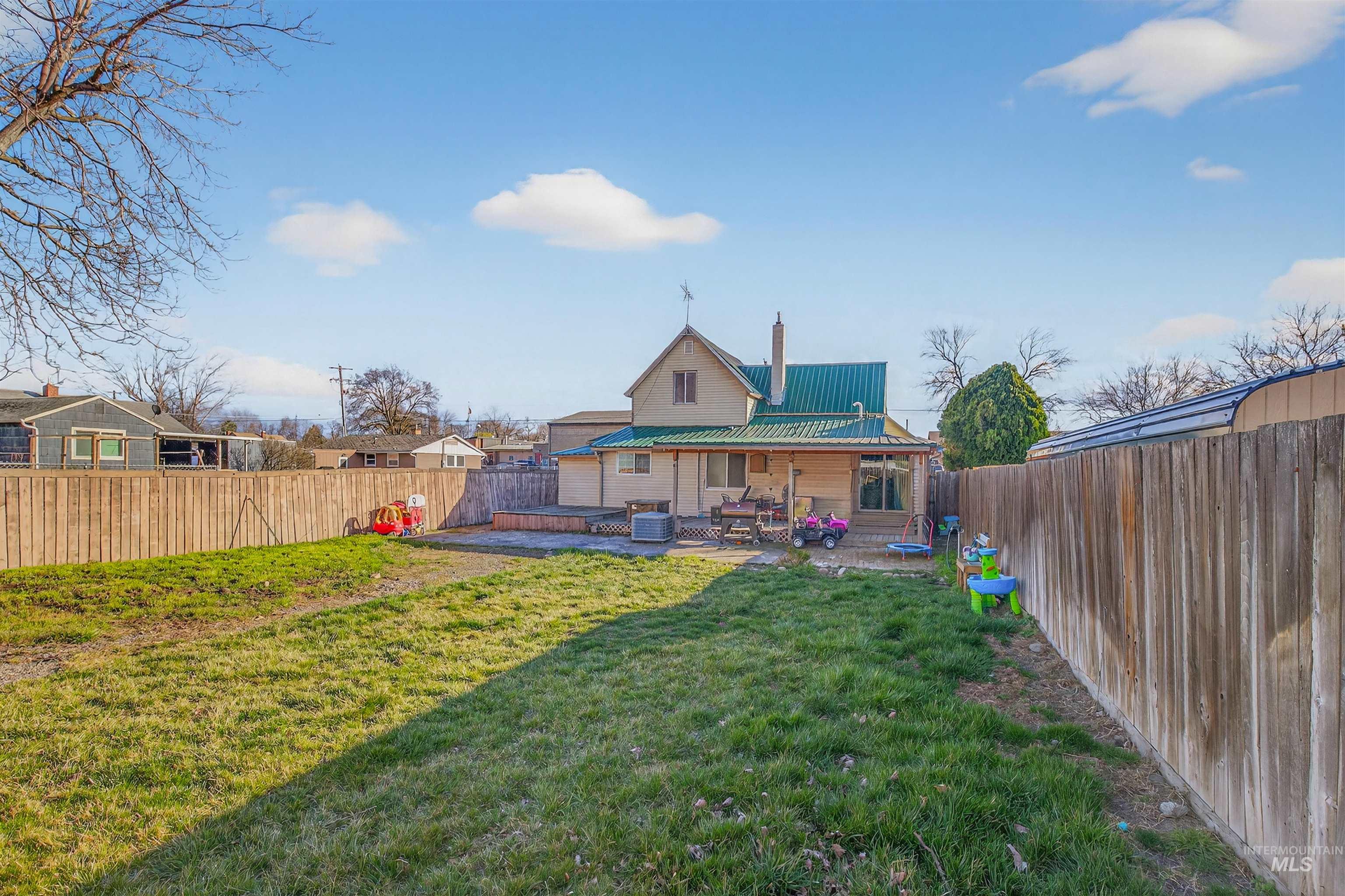 1266 Poplar Street Clarkston, WA 99403 - Photo 30 of 31 Rear view of property with a metal roof, a patio area, a fenced backyard, and a chimney