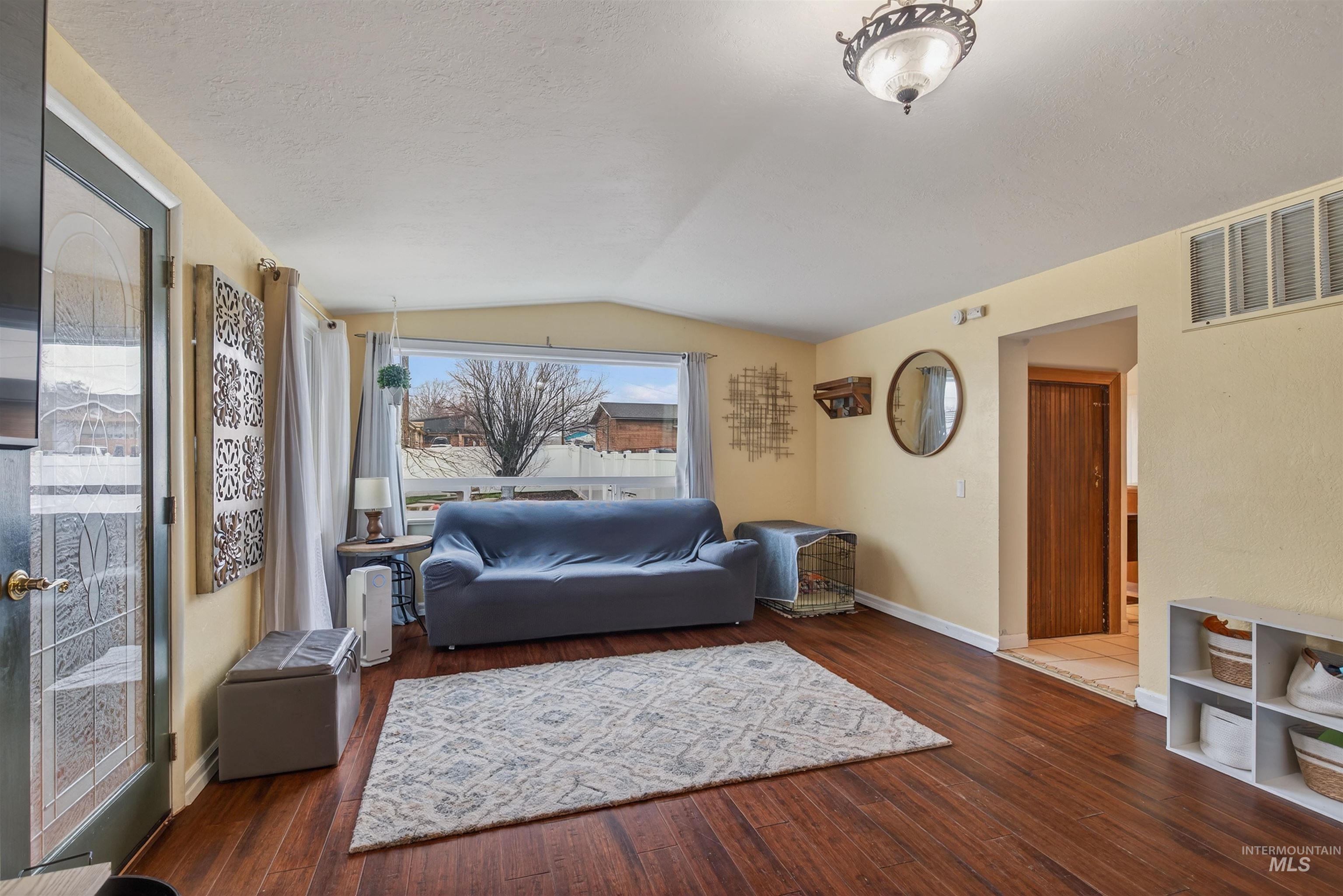 1266 Poplar Street Clarkston, WA 99403 - Photo 6 of 31 Living area featuring vaulted ceiling and dark wood-style flooring