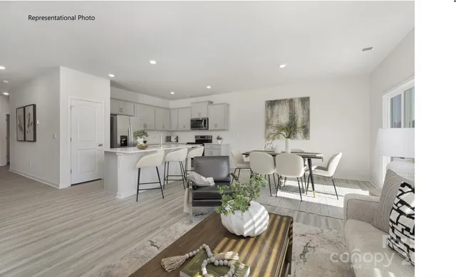 a living room with furniture and kitchen view
