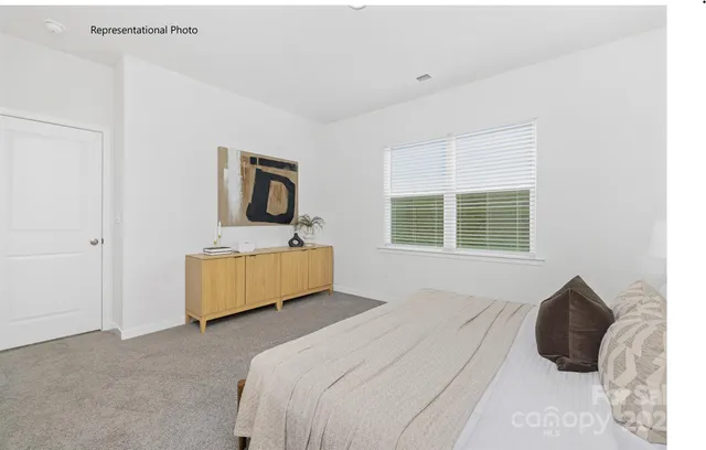 a bedroom with a bed next to a window with a flat screen tv