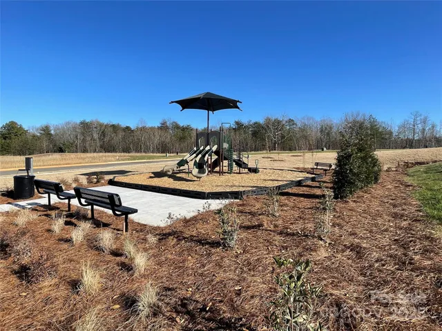 a view of a lake with a table and chairs under an umbrella