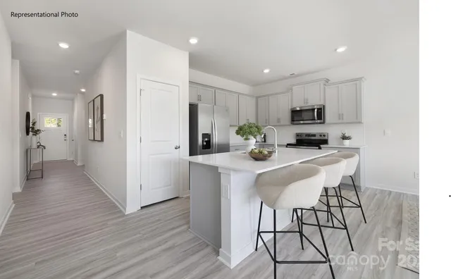 a kitchen with kitchen island white cabinets and stainless steel appliances