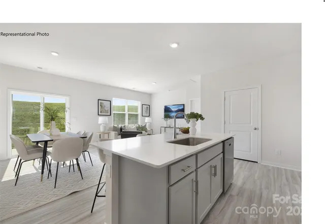 a view of a kitchen with a dining table chairs and a sink