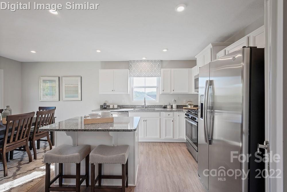 325 Damask Drive, Unit 118 Lancaster, SC 29720 - Photo 4 of 12 a kitchen with refrigerator cabinets dining table and chairs