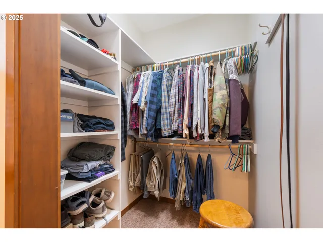 a view of walk in closet with clothes and shoes