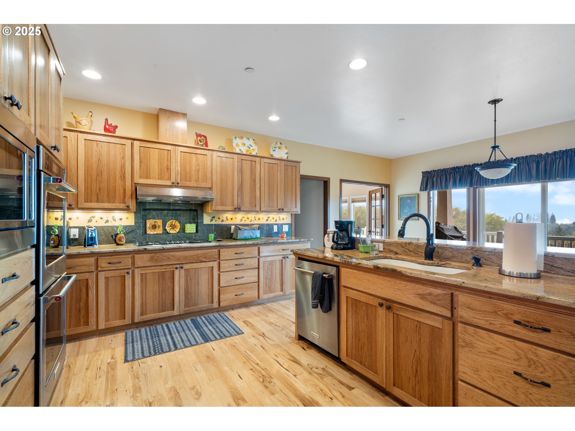 9500 Walz Hill Road Tillamook, OR 97141 - Photo 9 of 47 a kitchen with stainless steel appliances granite countertop a sink counter space cabinets and a large window