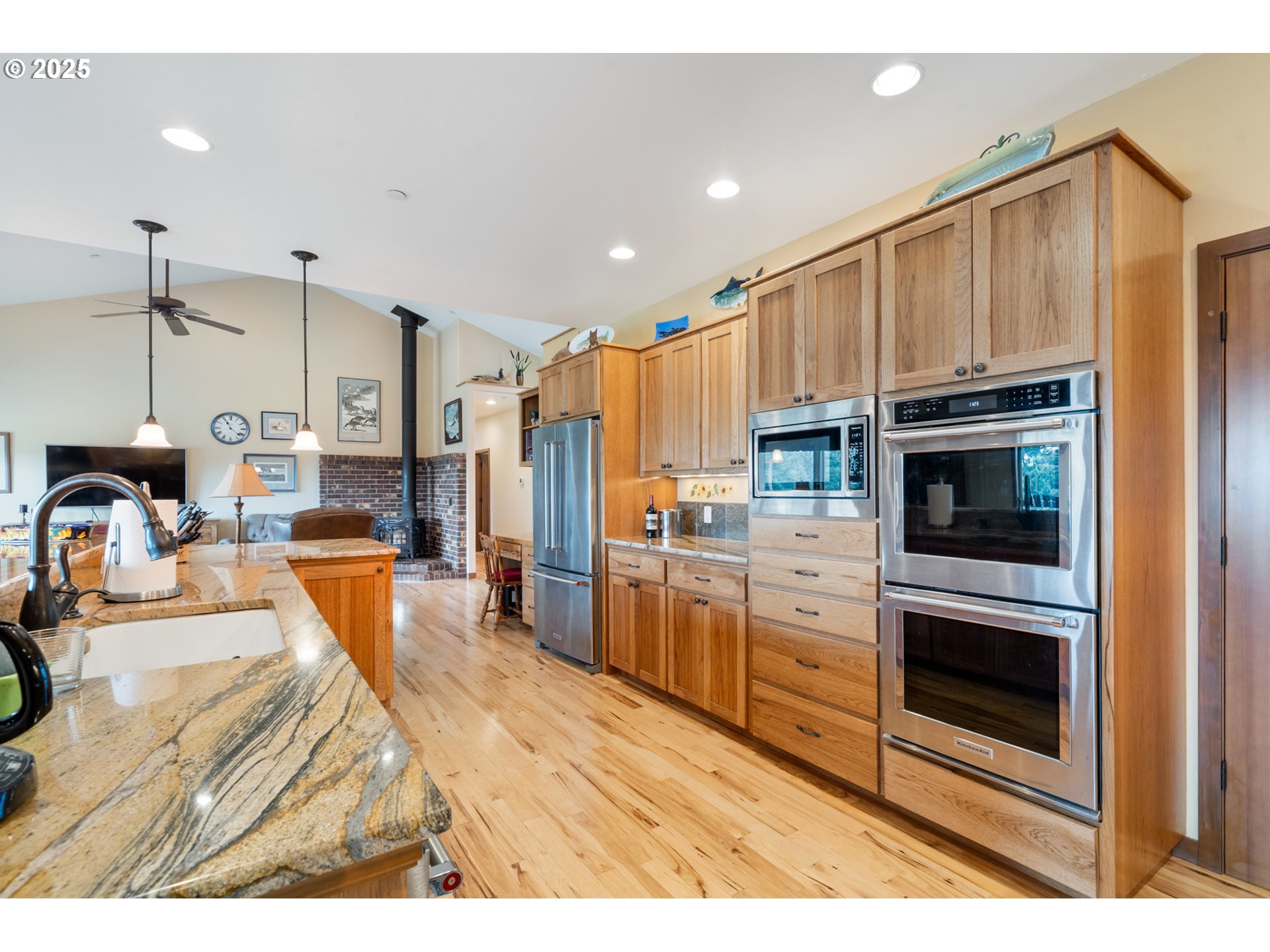 9500 Walz Hill Road Tillamook, OR 97141 - Photo 10 of 47 a kitchen with stainless steel appliances kitchen island granite countertop a refrigerator a stove and a sink with wooden floor