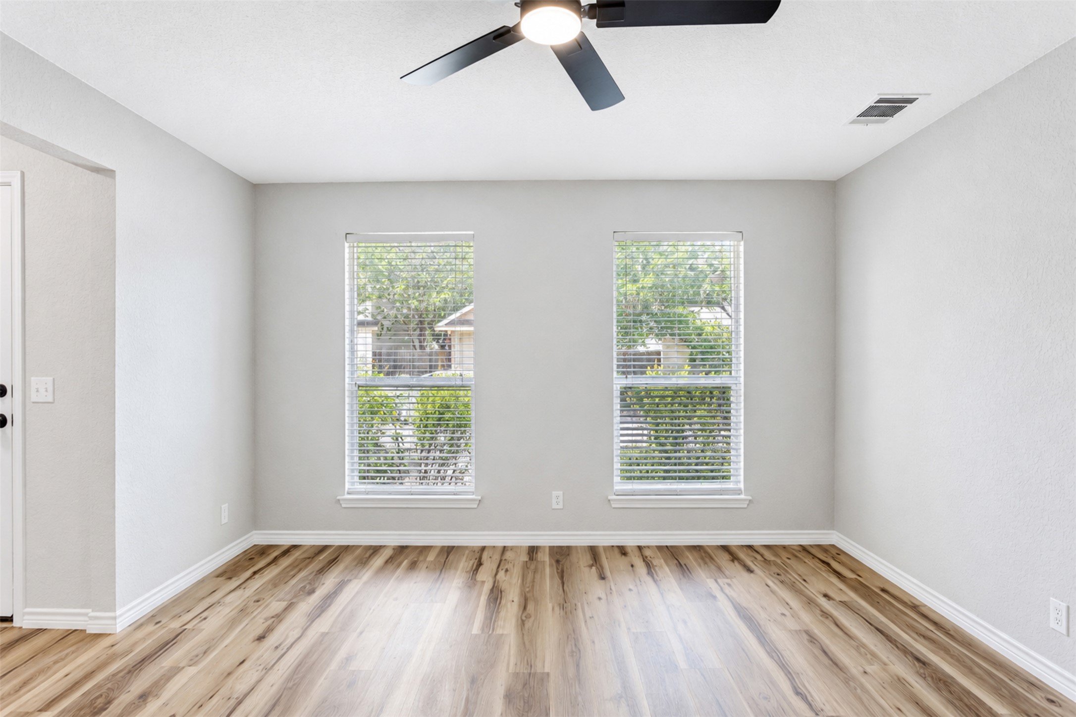 4523 Secure Lane Austin, TX 78725 - Photo 20 of 40 Hardwood floors and generous windows create a light-filled, inviting atmosphere in this versatile room.