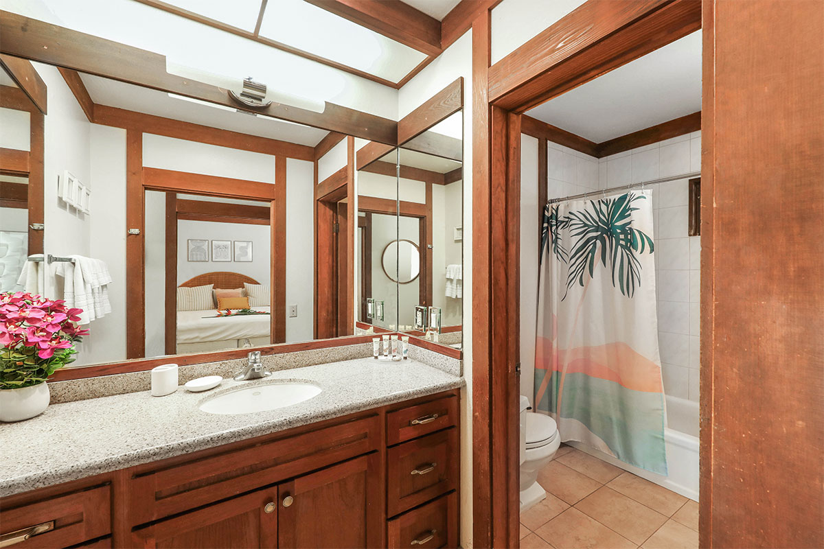 2253 Poipu Road, Unit 148 Koloa, HI 96756 - Photo 24 of 30 a bathroom with a granite countertop sink a mirror and a shower