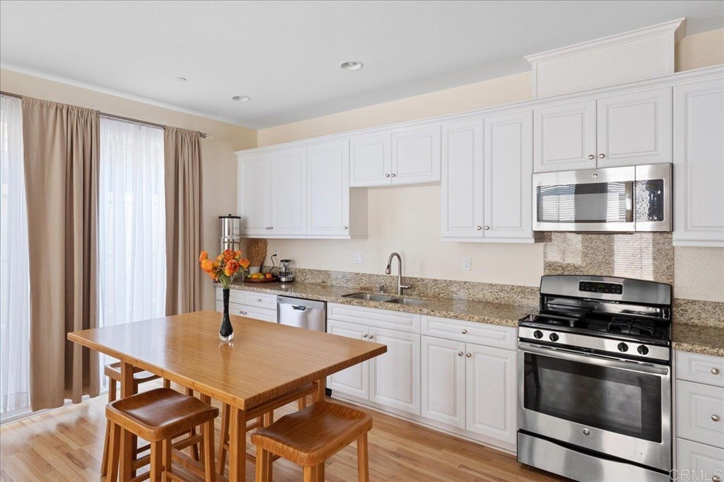 1347 Dolomite Way San Marcos, CA 92078 - Photo 8 of 23 a kitchen with stainless steel appliances a stove a sink dishwasher and cabinets