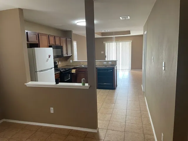 a view of kitchen with refrigerator and window