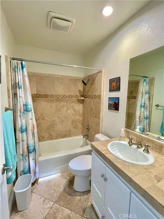 a bathroom with a granite countertop sink a toilet a mirror and bathtub