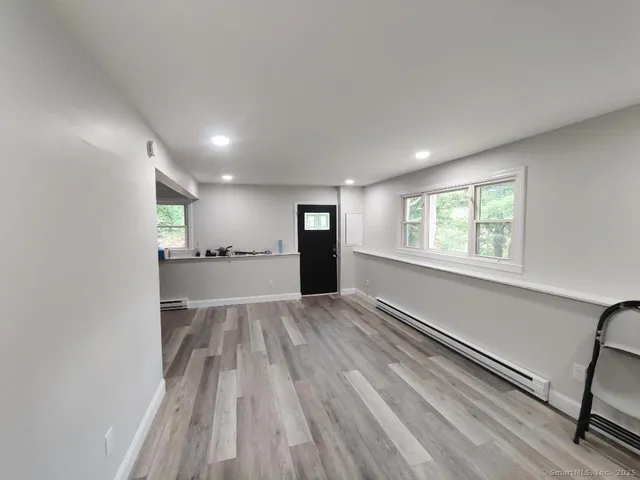 a view of empty room with wooden floor and window