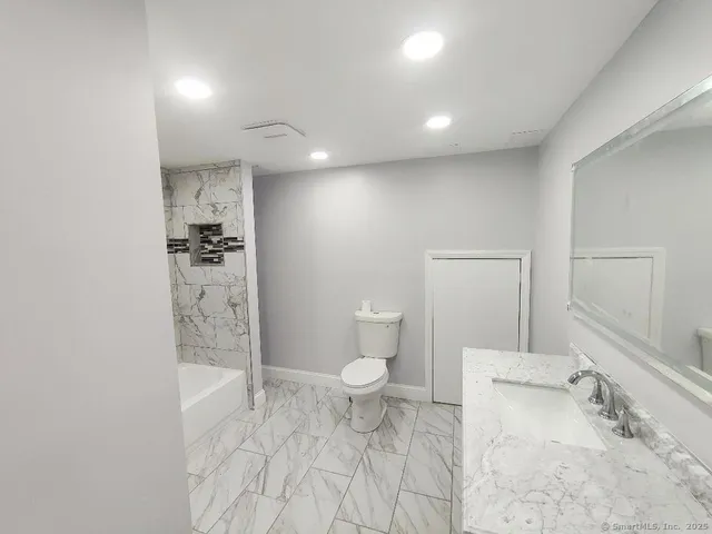a bathroom with a sink a toilet and shower