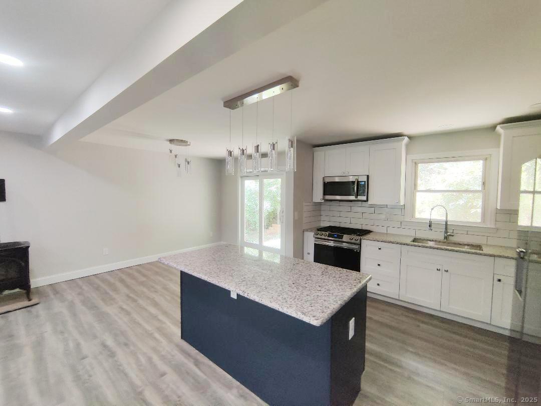 27 Paper Mill Road New Milford, CT 06776 - Photo 3 of 20 a large kitchen with granite countertop a stove top oven a sink dishwasher and a refrigerator with wooden floor