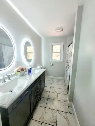 a bathroom with a double vanity sink and a mirror