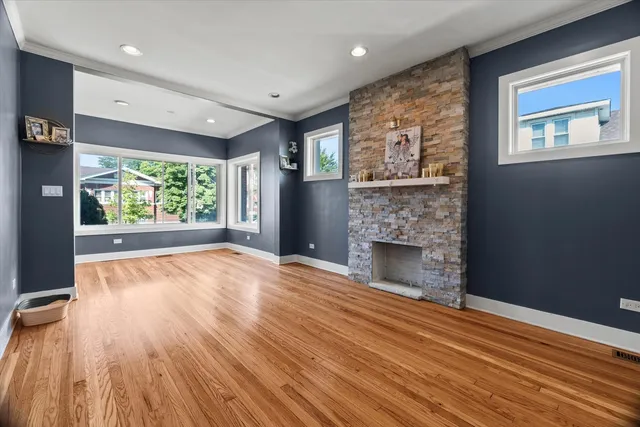 a view of empty room with wooden floor and fireplace
