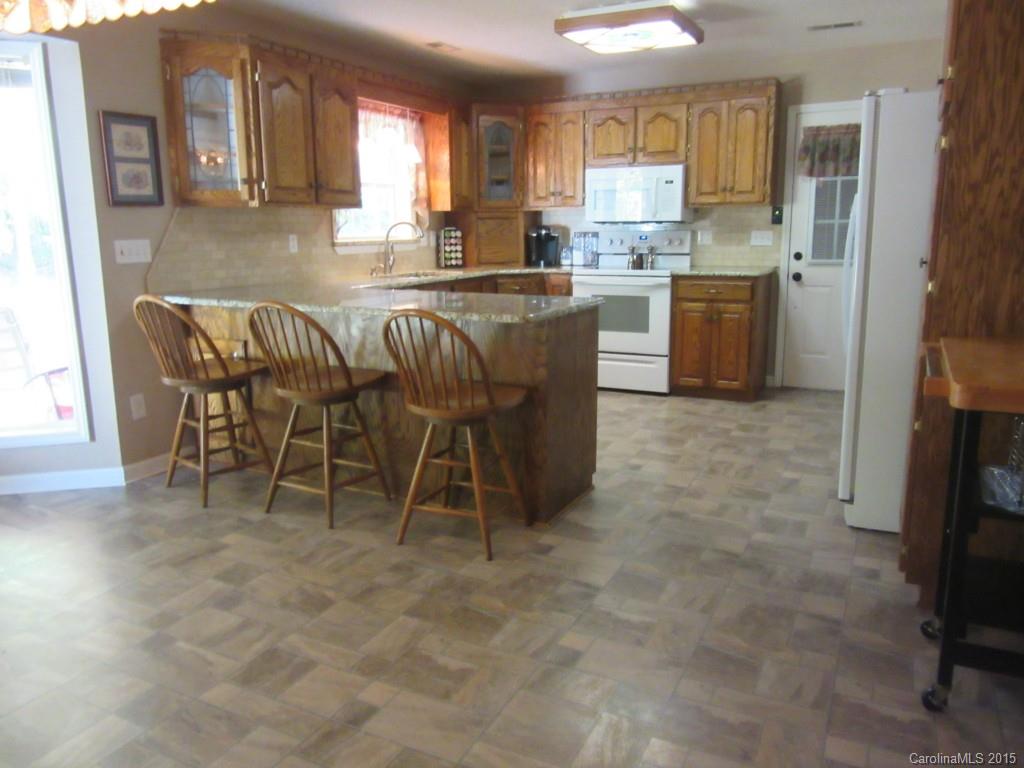575 Russell Farm Road Kannapolis, NC 28081 - Photo 6 of 23 a kitchen with stainless steel appliances granite countertop a stove a sink a dining table and chairs