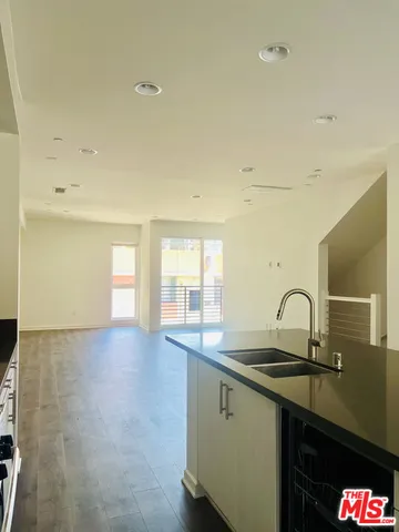 a kitchen with granite countertop a sink and cabinets