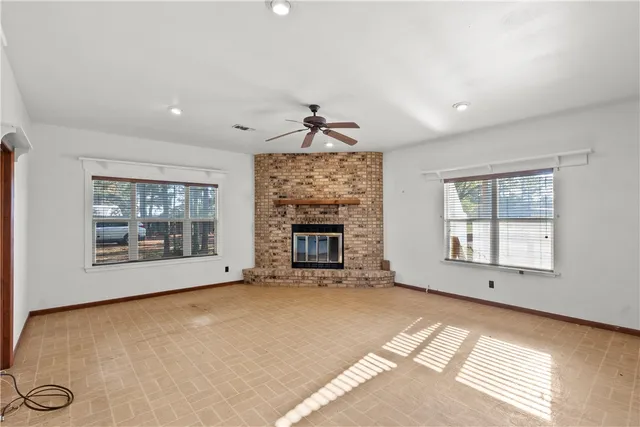a view of an empty room with a fireplace and a window